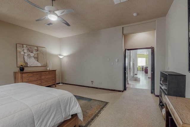 bedroom featuring baseboards, a textured ceiling, visible vents, ceiling fan, and light colored carpet