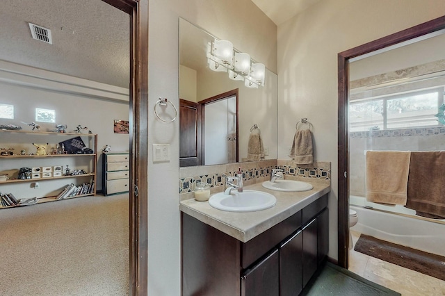 bathroom featuring a sink, visible vents, toilet, and backsplash