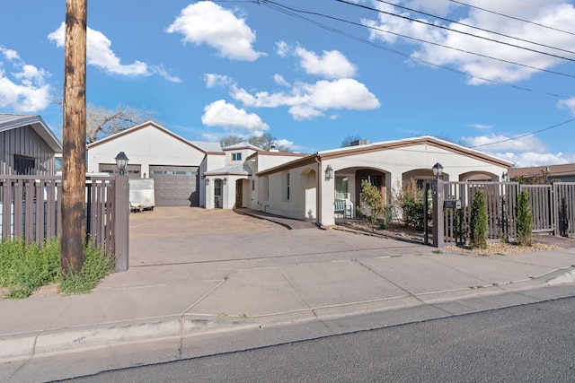 2912 William St SE, Albuquerque, NM 87102 - mediterranean / spanish home featuring concrete driveway, fence, covered porch, and stucco siding