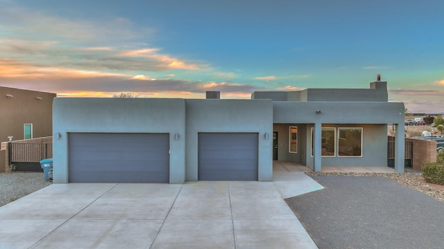4621 27th Ave NE, Rio Rancho, NM 87144 - pueblo-style house with a garage, concrete driveway, and stucco siding
