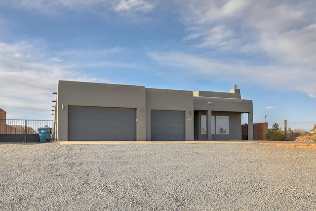 4621 27th Ave NE, Rio Rancho, NM 87144 - pueblo-style home with stucco siding, driveway, and a garage
