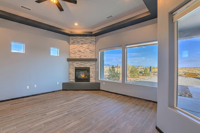 4621 27th Ave NE, Rio Rancho, NM 87144 - unfurnished living room featuring ceiling fan, wood finished floors, a raised ceiling, plenty of natural light, and recessed lighting