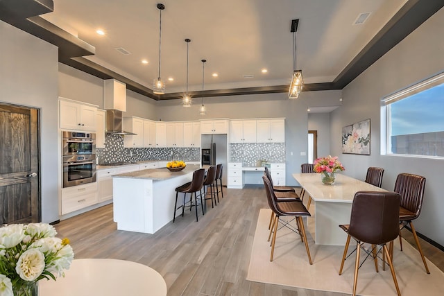 4621 27th Ave NE, Rio Rancho, NM 87144 - kitchen featuring wall chimney exhaust hood, appliances with stainless steel finishes, a spacious island, backsplash, and recessed lighting