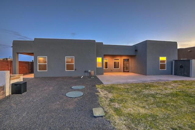 4621 27th Ave NE, Rio Rancho, NM 87144 - back of property at dusk with a patio area and stucco siding
