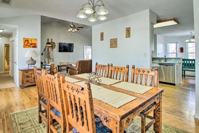dining area with light wood-style floors, visible vents, and ceiling fan with notable chandelier