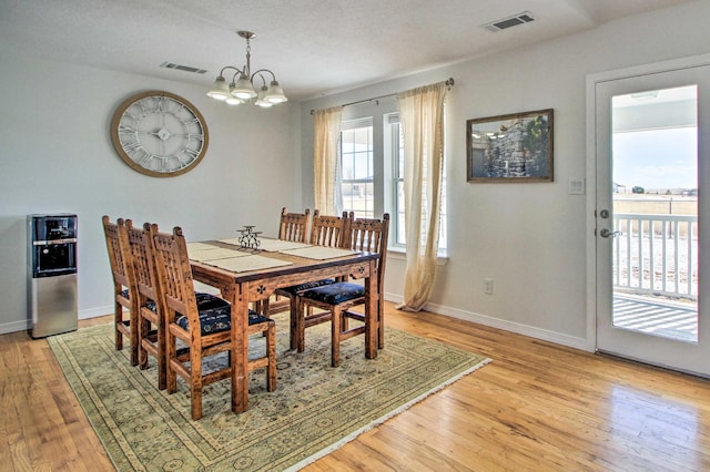 dining space featuring light wood-style flooring and visible vents