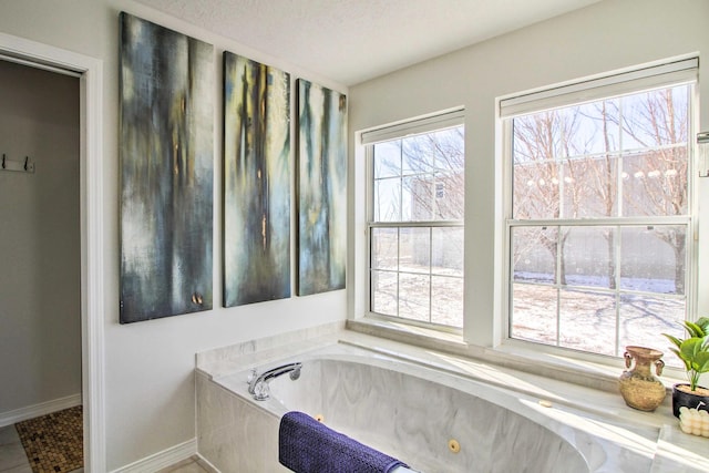 full bathroom with baseboards and a tub with jets