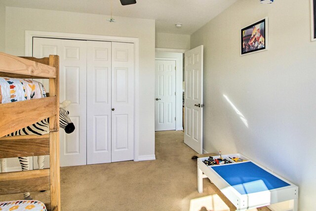 bedroom featuring a closet, carpet flooring, baseboards, and ceiling fan