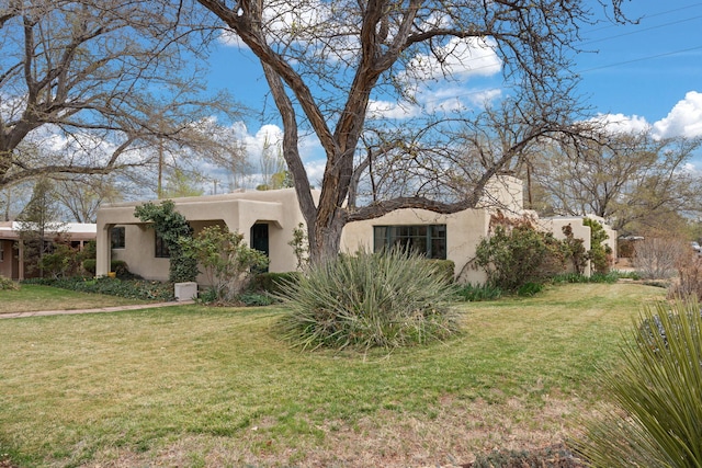 view of front facade with a front lawn and stucco siding
