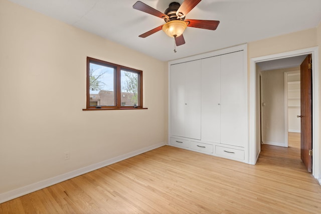 unfurnished bedroom with light wood-type flooring, a ceiling fan, baseboards, and a closet