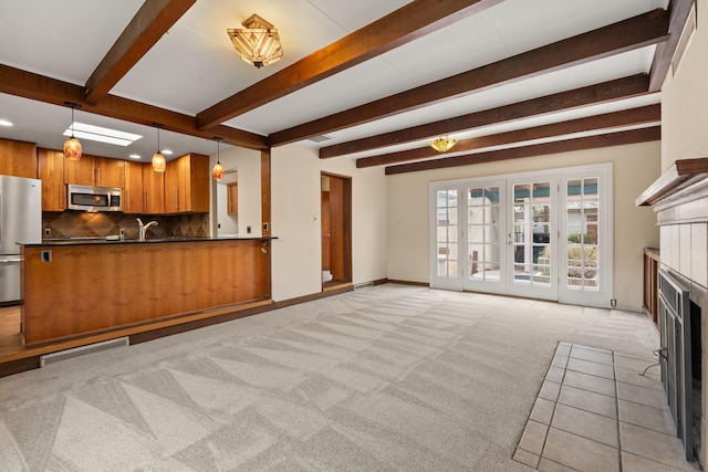 unfurnished living room with recessed lighting, visible vents, beam ceiling, a fireplace, and light colored carpet