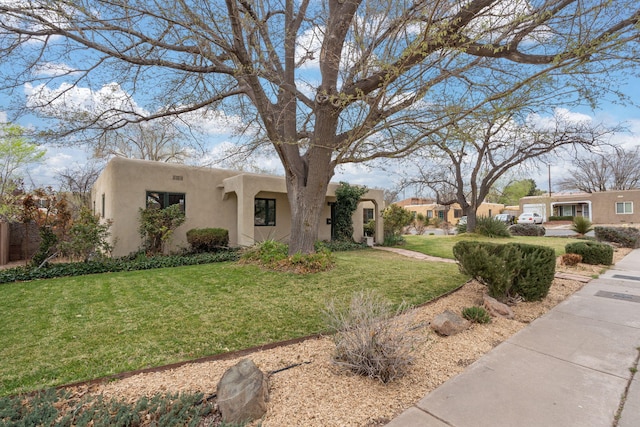 view of front of home featuring stucco siding and a front lawn