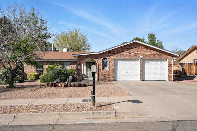 single story home featuring an attached garage, driveway, and brick siding