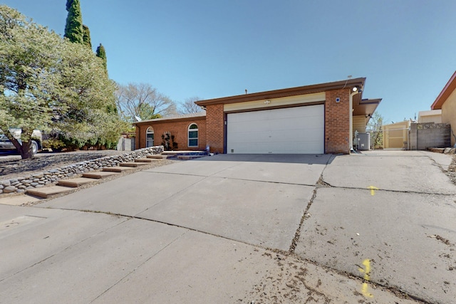 8021 Ruidoso Ct NE, Albuquerque, NM 87109 - view of home's exterior with a gate, cooling unit, an attached garage, driveway, and brick siding