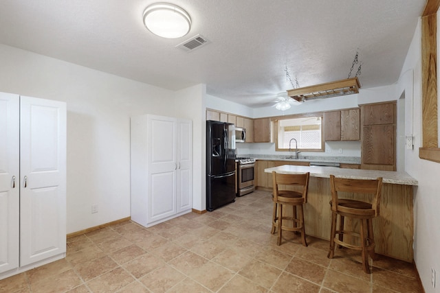 8021 Ruidoso Ct NE, Albuquerque, NM 87109 - kitchen with stainless steel appliances, a peninsula, a sink, visible vents, and light countertops