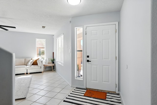 5909 Night Shadow Ave NW, Albuquerque, NM 87114 - entryway with a textured ceiling, light tile patterned floors, a ceiling fan, and baseboards