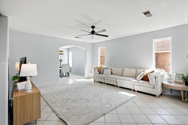 5909 Night Shadow Ave NW, Albuquerque, NM 87114 - living area with arched walkways, ceiling fan, light tile patterned floors, and a textured ceiling