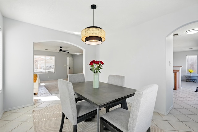5909 Night Shadow Ave NW, Albuquerque, NM 87114 - dining space with arched walkways, light tile patterned floors, ceiling fan, and healthy amount of natural light