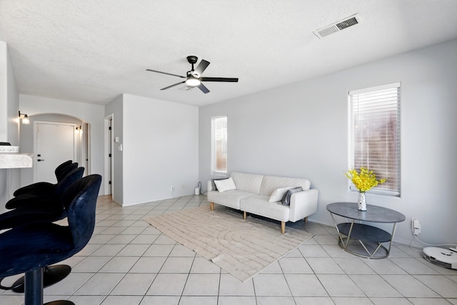 5909 Night Shadow Ave NW, Albuquerque, NM 87114 - living area with ceiling fan, plenty of natural light, arched walkways, a textured ceiling, and light tile patterned floors