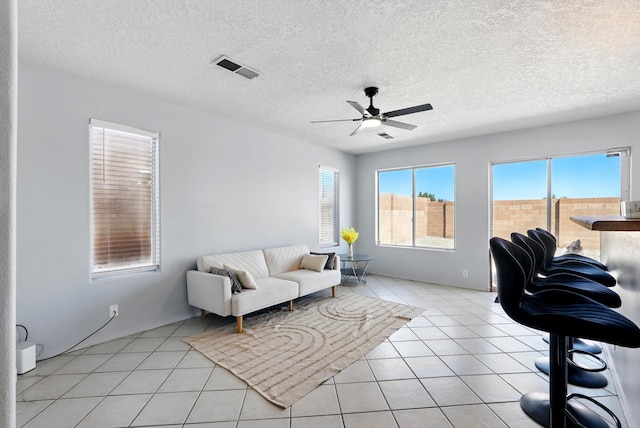 5909 Night Shadow Ave NW, Albuquerque, NM 87114 - living area featuring ceiling fan, light tile patterned flooring, a textured ceiling, and baseboards