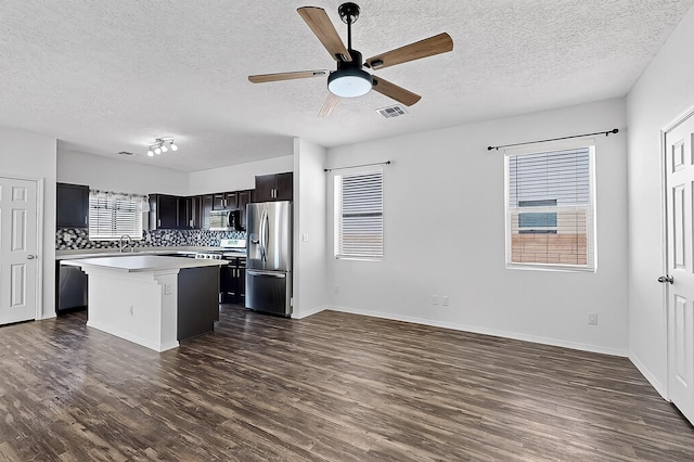 6300 Gannett Dr NE, Rio Rancho, NM 87144 - kitchen featuring stainless steel appliances, light countertops, dark wood-style floors, a center island, and a textured ceiling
