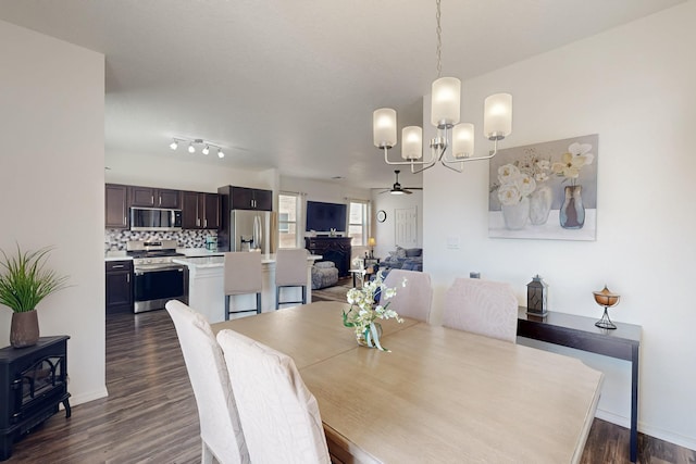 6300 Gannett Dr NE, Rio Rancho, NM 87144 - dining room featuring a ceiling fan, dark wood-style floors, a wood stove, and a chandelier