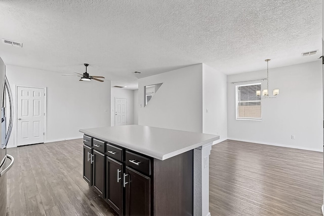 6300 Gannett Dr NE, Rio Rancho, NM 87144 - kitchen featuring light wood-style floors, a chandelier, a ceiling fan, open floor plan, and a textured ceiling