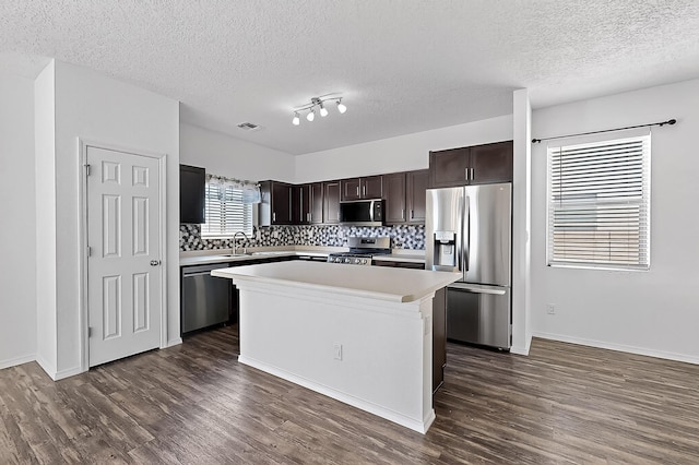 6300 Gannett Dr NE, Rio Rancho, NM 87144 - kitchen featuring appliances with stainless steel finishes, light countertops, dark brown cabinets, dark wood-style flooring, and decorative backsplash
