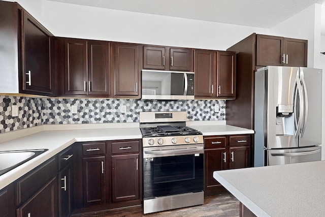 6300 Gannett Dr NE, Rio Rancho, NM 87144 - kitchen featuring appliances with stainless steel finishes, light countertops, dark wood-style flooring, dark brown cabinets, and backsplash