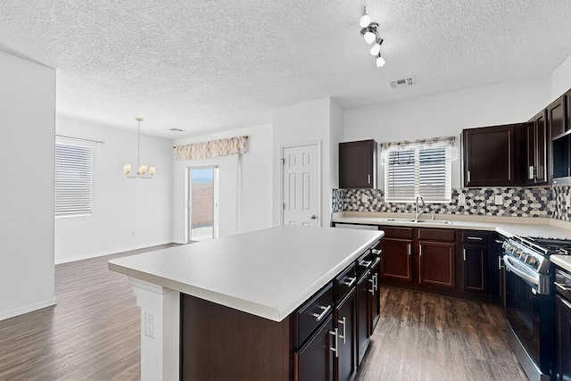 6300 Gannett Dr NE, Rio Rancho, NM 87144 - kitchen featuring gas range, dark wood finished floors, a chandelier, light countertops, and a textured ceiling