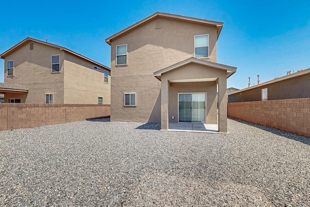 6300 Gannett Dr NE, Rio Rancho, NM 87144 - rear view of house with a fenced backyard, stucco siding, and a patio area