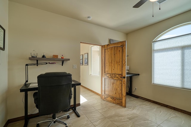 office area with a ceiling fan, baseboards, and light tile patterned flooring