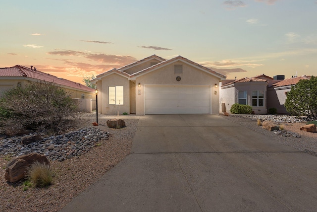 275 Chaparral Loop SE, Rio Rancho, NM 87124 - view of front of home with stucco siding, an attached garage, concrete driveway, and a tiled roof