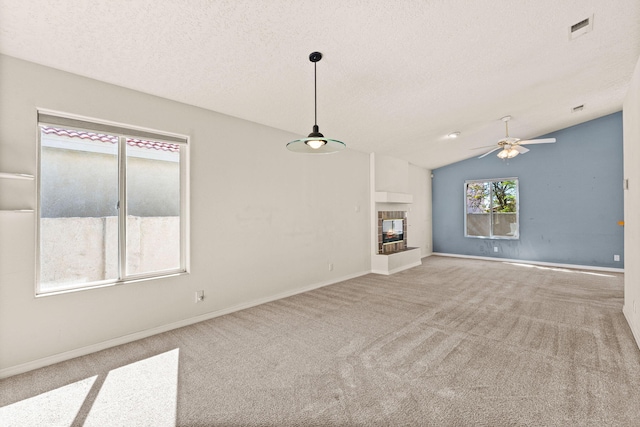 275 Chaparral Loop SE, Rio Rancho, NM 87124 - unfurnished living room featuring a tile fireplace, visible vents, a textured ceiling, and carpet flooring