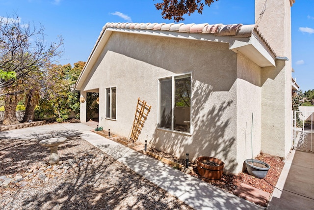 275 Chaparral Loop SE, Rio Rancho, NM 87124 - view of side of home featuring fence, a tile roof, a patio, and stucco siding