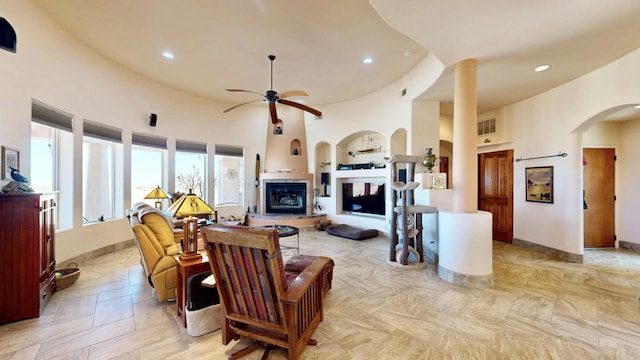 living area with recessed lighting, arched walkways, and a towering ceiling