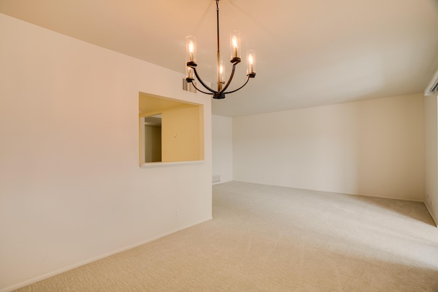 unfurnished room featuring an inviting chandelier, carpet flooring, and visible vents