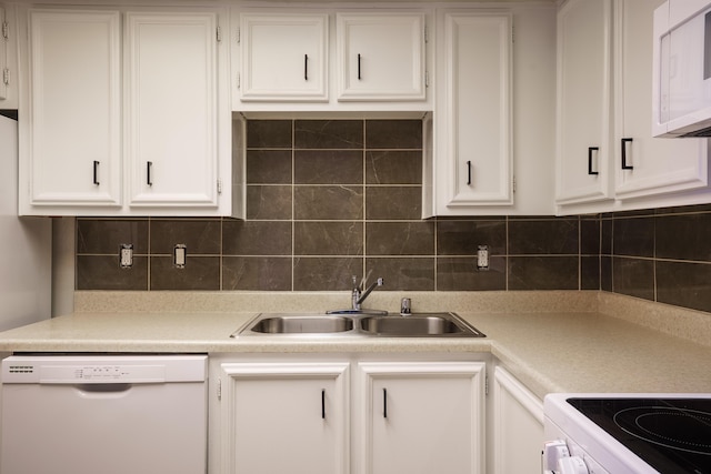 kitchen with a sink, white appliances, light countertops, white cabinetry, and decorative backsplash