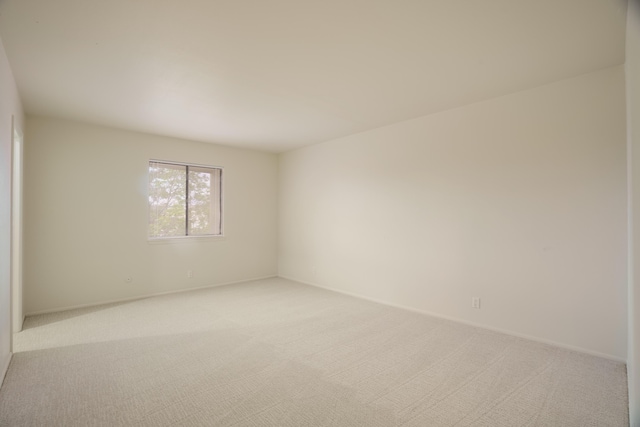 empty room with baseboards and light carpet