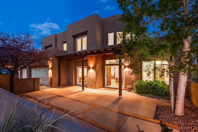 pueblo revival-style home with fence