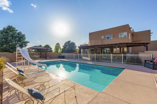 view of pool featuring a gazebo, a patio area, fence, a fenced in pool, and a water slide