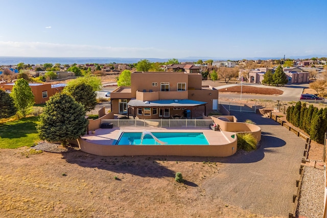 view of swimming pool with a water slide, a patio, a residential view, and a fenced in pool