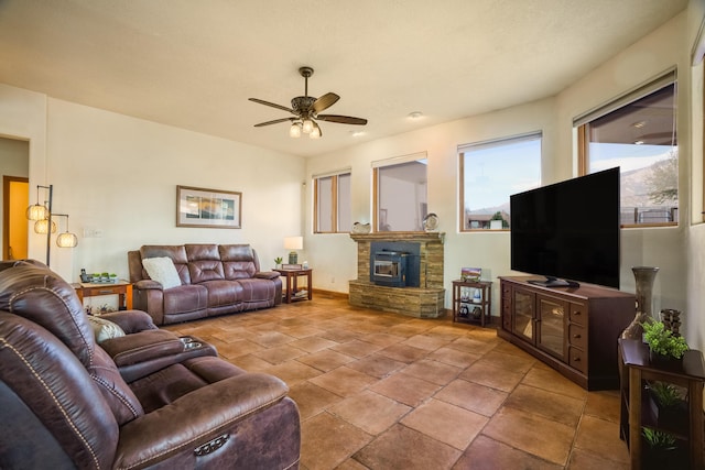 living area featuring a fireplace, a ceiling fan, and baseboards