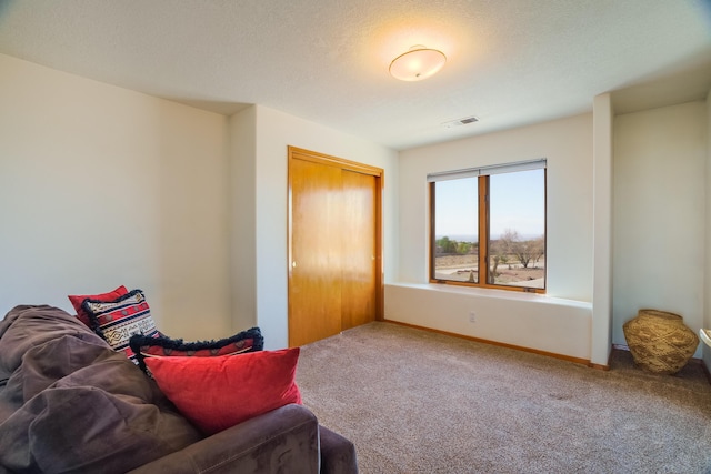 living area with carpet floors, visible vents, and baseboards