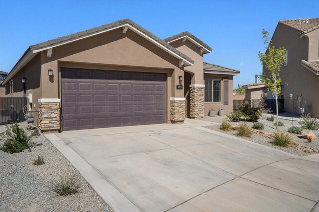3003 Turquesa SE, Rio Rancho, NM 87124 - view of front of house featuring stone siding, stucco siding, a garage, and concrete driveway