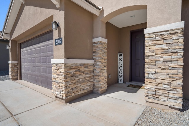 3003 Turquesa SE, Rio Rancho, NM 87124 - doorway to property with stone siding, stucco siding, concrete driveway, and a garage