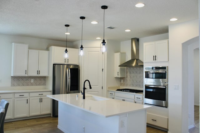 3003 Turquesa SE, Rio Rancho, NM 87124 - kitchen with wall chimney exhaust hood, stainless steel appliances, a sink, wood finished floors, and tasteful backsplash