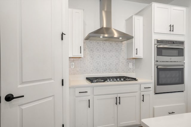 3003 Turquesa SE, Rio Rancho, NM 87124 - kitchen featuring wall chimney exhaust hood, stainless steel appliances, white cabinetry, backsplash, and light countertops