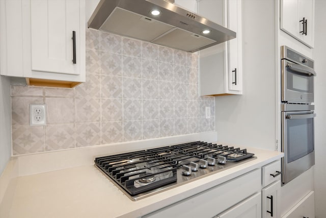 3003 Turquesa SE, Rio Rancho, NM 87124 - kitchen with ventilation hood, appliances with stainless steel finishes, white cabinets, light countertops, and backsplash