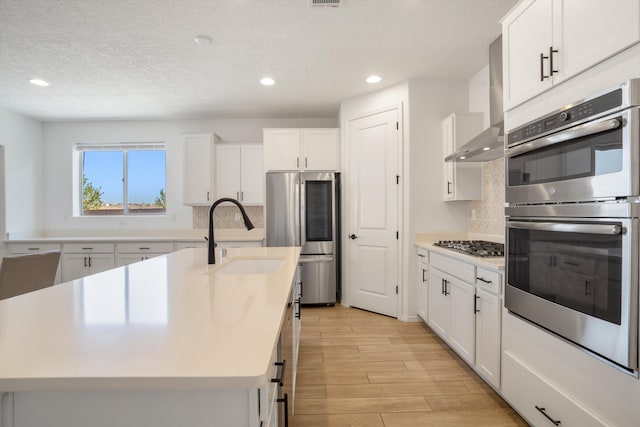 3003 Turquesa SE, Rio Rancho, NM 87124 - kitchen featuring stainless steel appliances, a sink, tasteful backsplash, light wood-style floors, and a textured ceiling